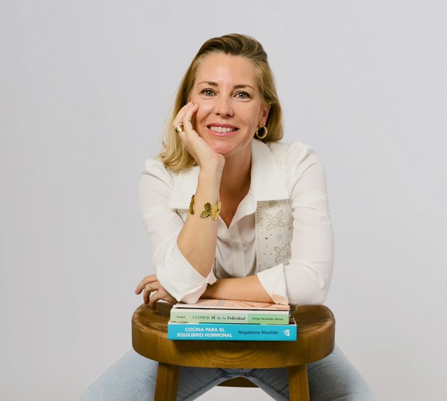 Beatriz, sonriendo, con sus libros de nutrición